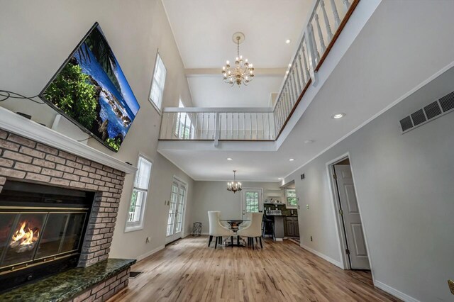 14 Ace Ln, East Stroudsburg, PA 18301 - living room with a chandelier, wood finished floors, baseboards, a high ceiling, and a fireplace
