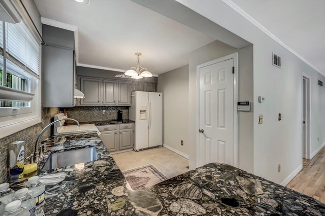 14 Ace Ln, East Stroudsburg, PA 18301 - kitchen featuring white refrigerator with ice dispenser, a sink, decorative backsplash, a chandelier, and under cabinet range hood