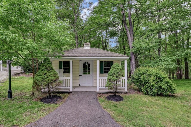 14 Ace Ln, East Stroudsburg, PA 18301 - bungalow-style home with a shingled roof, covered porch, a chimney, and a front yard