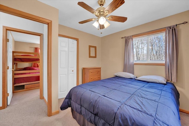 carpeted bedroom with a ceiling fan, baseboards, and a closet