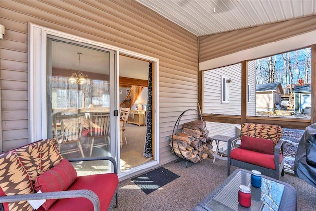 sunroom / solarium featuring a notable chandelier