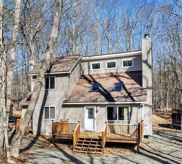 rear view of property with a chimney and a wooden deck