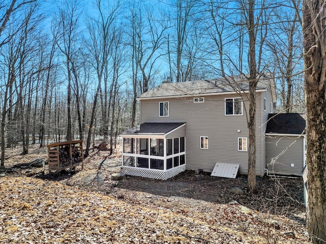 back of property with a sunroom and a chimney