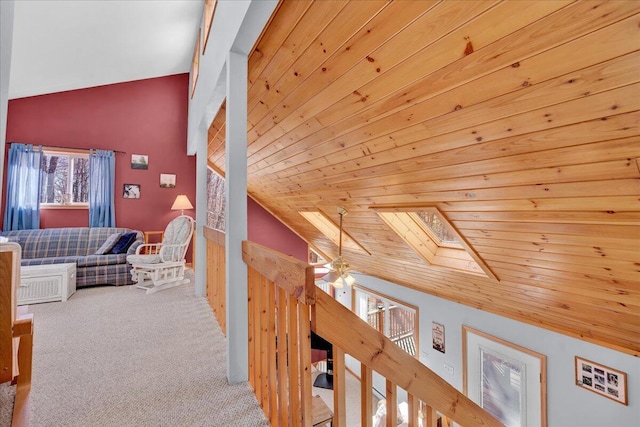 hall featuring lofted ceiling with skylight, wood ceiling, and carpet flooring