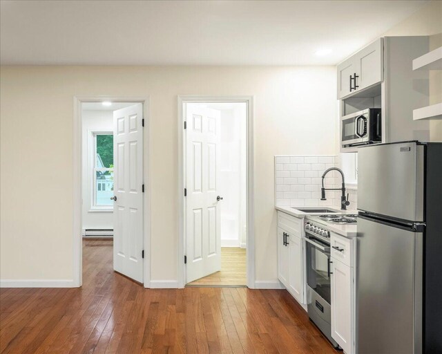 428 Shook Ave, Stroudsburg, PA 18360 - kitchen featuring appliances with stainless steel finishes, baseboard heating, open shelves, hardwood / wood-style floors, and recessed lighting