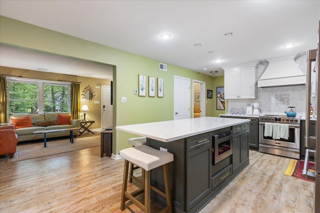 71 Pope Ln, Albrightsville, PA 18210 - kitchen featuring stainless steel appliances, custom exhaust hood, white cabinetry, light countertops, and light wood-type flooring