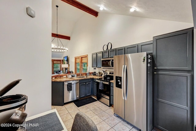 kitchen with beam ceiling, light tile patterned floors, stainless steel appliances, hanging light fixtures, and a sink