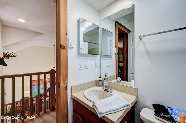 bathroom featuring toilet, recessed lighting, and vanity