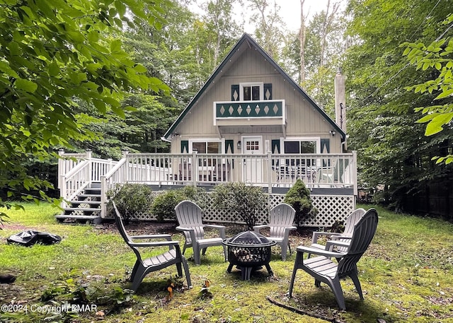 back of property featuring a fire pit, stairway, and a wooden deck