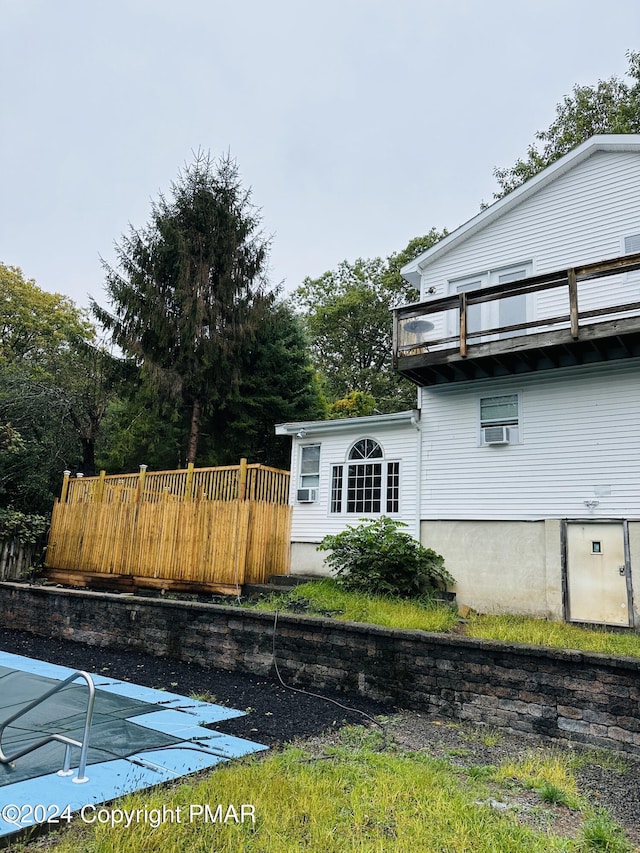 view of property exterior with a balcony and fence