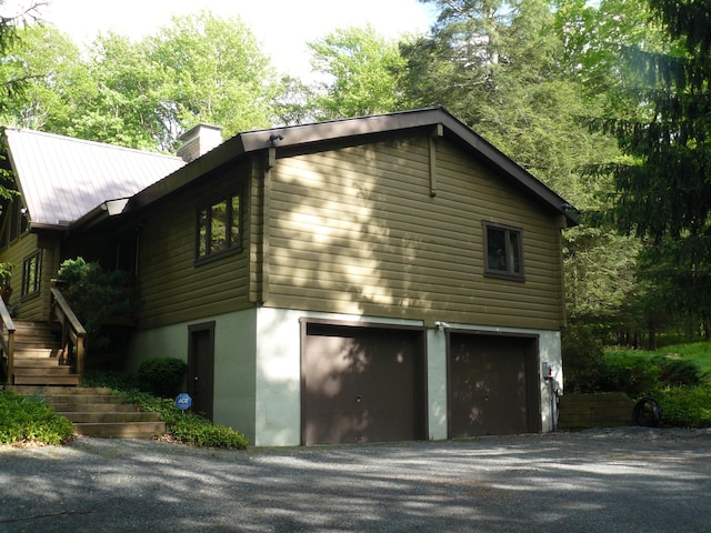1006 Mill Creek Rd, Newfoundland, PA 18445 - view of home's exterior with a garage, a chimney, driveway, and stairway