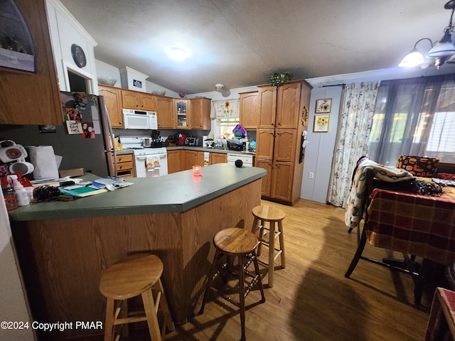 kitchen featuring lofted ceiling, light wood-style flooring, glass insert cabinets, white appliances, and a peninsula