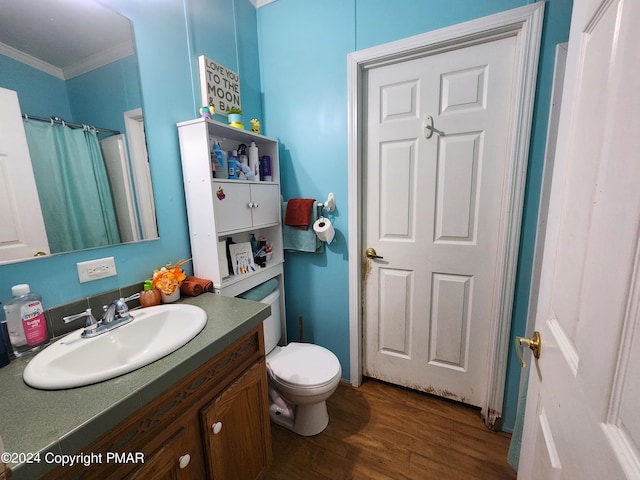 bathroom featuring toilet, wood finished floors, vanity, and crown molding