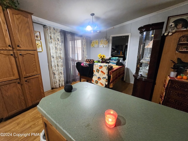 dining space featuring a notable chandelier, light wood-style floors, and crown molding