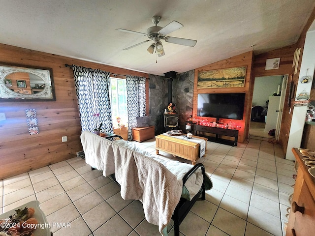 living room with lofted ceiling, a wood stove, wood walls, and light tile patterned floors