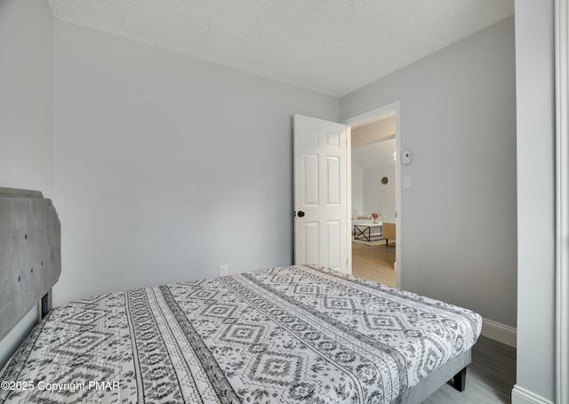 bedroom featuring hardwood / wood-style floors and a textured ceiling