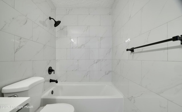 full bathroom with vanity, toilet, tiled shower / bath combo, and a textured ceiling