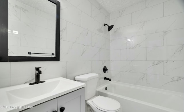 full bathroom with toilet, a textured ceiling, tile walls, vanity, and tiled shower / bath combo