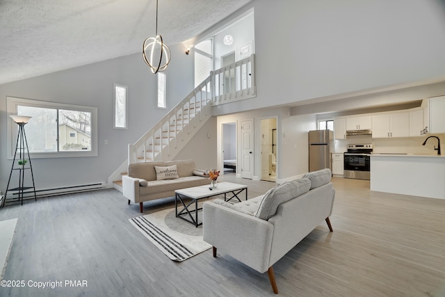 living room with vaulted ceiling, a baseboard radiator, sink, light hardwood / wood-style floors, and a textured ceiling