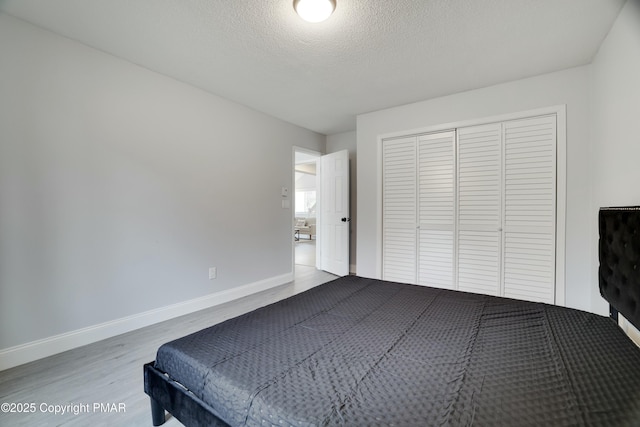 unfurnished bedroom with hardwood / wood-style flooring, a closet, and a textured ceiling