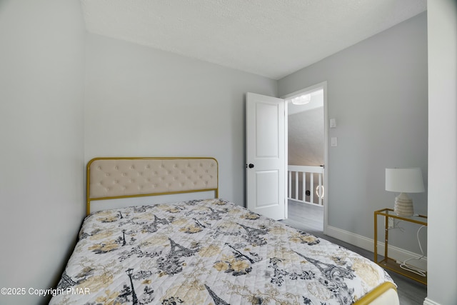 bedroom with wood-type flooring and a textured ceiling