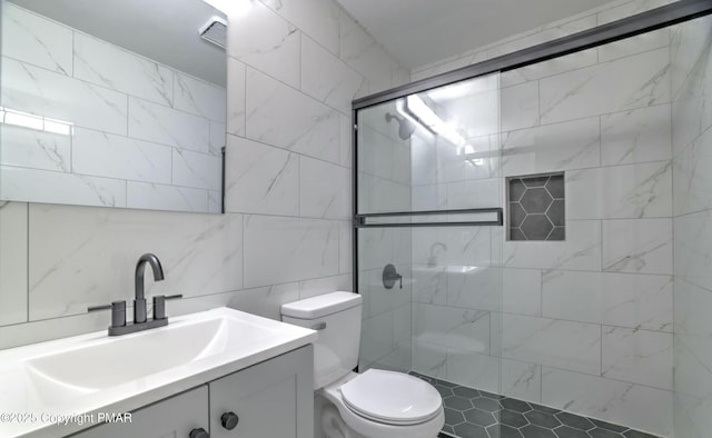 bathroom featuring tasteful backsplash, tile walls, vanity, walk in shower, and toilet