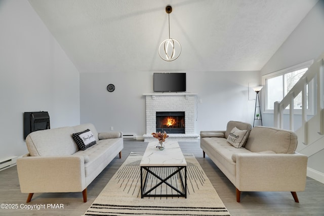 living room featuring lofted ceiling, a brick fireplace, dark hardwood / wood-style floors, and a textured ceiling