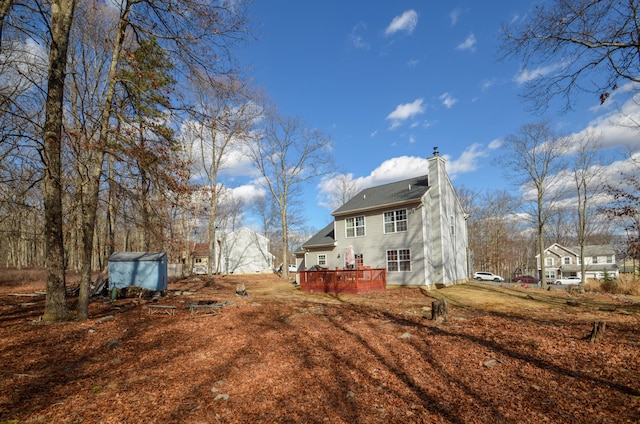 rear view of property with a wooden deck and a chimney