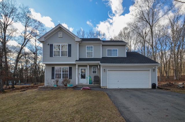 traditional-style house with aphalt driveway, a garage, and a front lawn