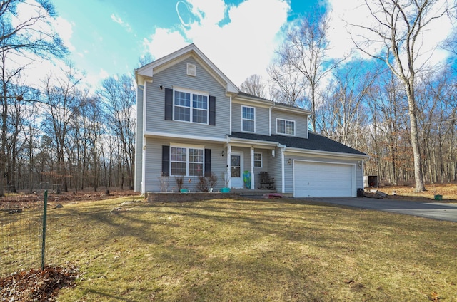 traditional-style house with aphalt driveway, an attached garage, and a front yard