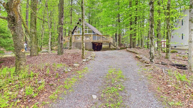 112 Moshannon Dr, Pocono Lake, PA 18347 - view of front of property featuring gravel driveway, a deck, stairs, and a forest view