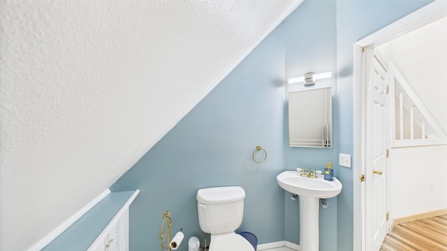 112 Moshannon Dr, Pocono Lake, PA 18347 - bathroom with a textured ceiling, a sink, toilet, wood finished floors, and vaulted ceiling