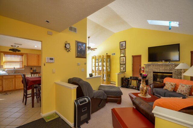 1214 Shadblow Rd, Pocono Summit, PA 18346 - living area with lofted ceiling, a fireplace, ceiling fan, a skylight, and light tile patterned flooring
