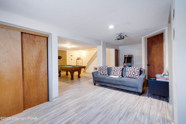 living room featuring light wood-style flooring, stairs, and pool table