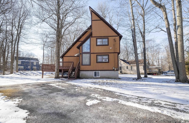 snow covered house with a wooden deck