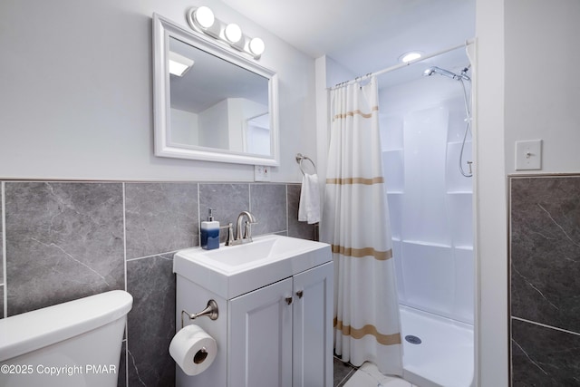 bathroom with curtained shower, vanity, toilet, and tile walls