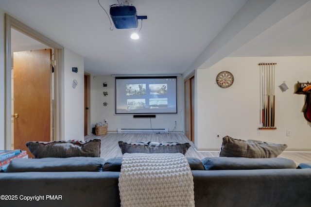 home theater room featuring a baseboard heating unit, wood finished floors, and baseboards