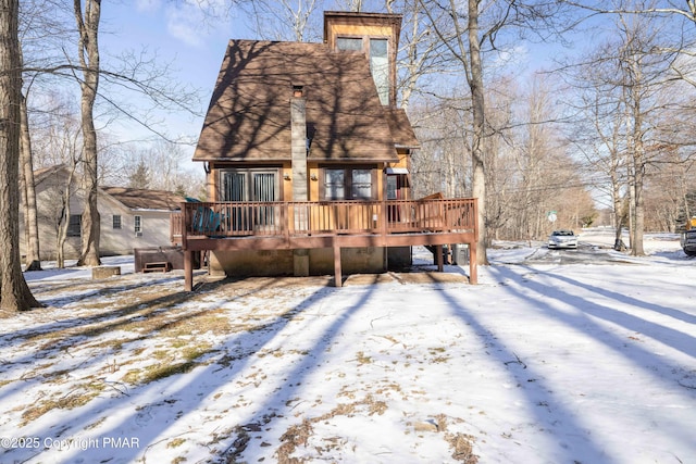 snow covered house with a deck