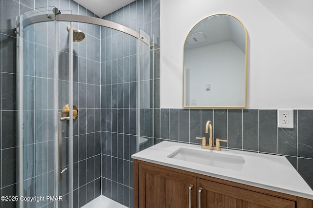 bathroom featuring vanity, tile walls, and a stall shower