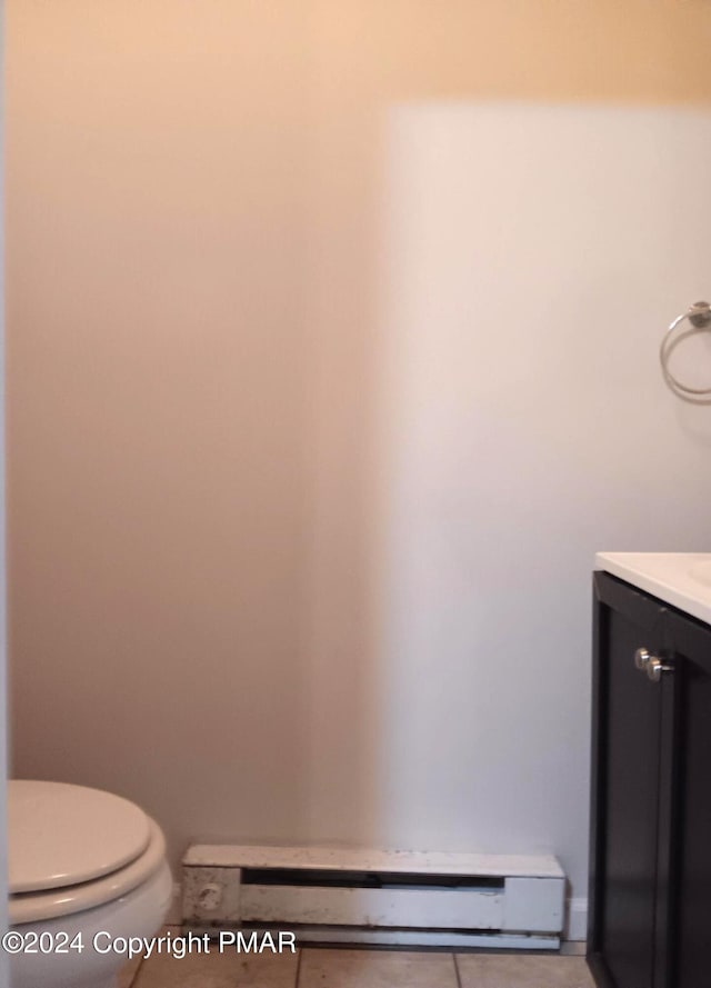 half bath with toilet, a baseboard radiator, and vanity