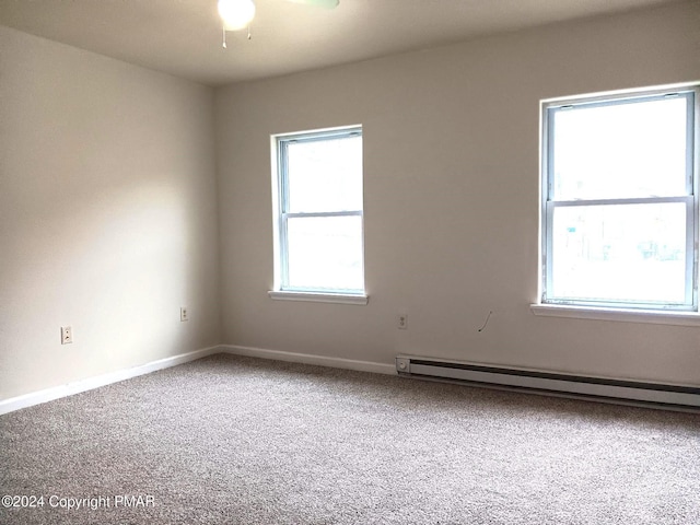 carpeted spare room with a baseboard radiator and baseboards