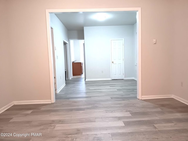 empty room featuring wood finished floors and baseboards