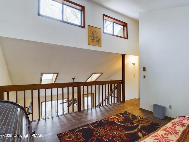 interior space featuring a high ceiling, a skylight, and wood finished floors