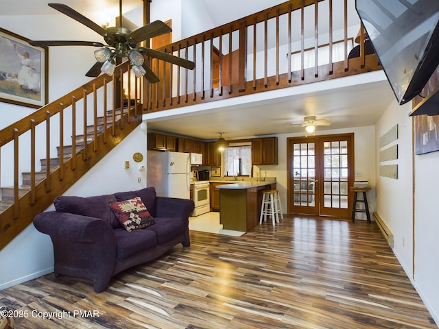 living area featuring baseboards, stairway, wood finished floors, and french doors