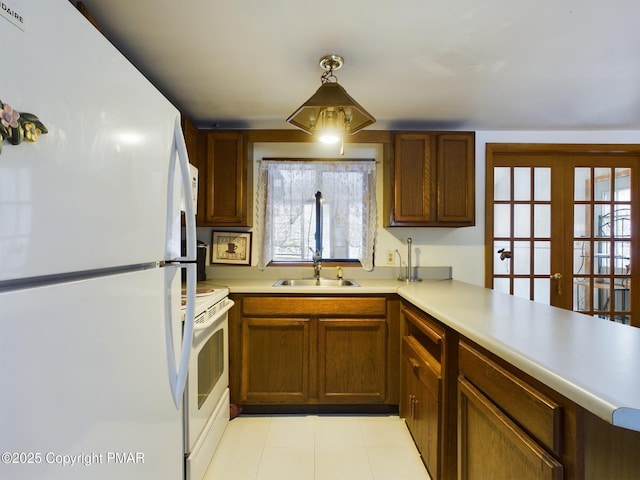 kitchen featuring white appliances, brown cabinetry, light countertops, french doors, and a sink