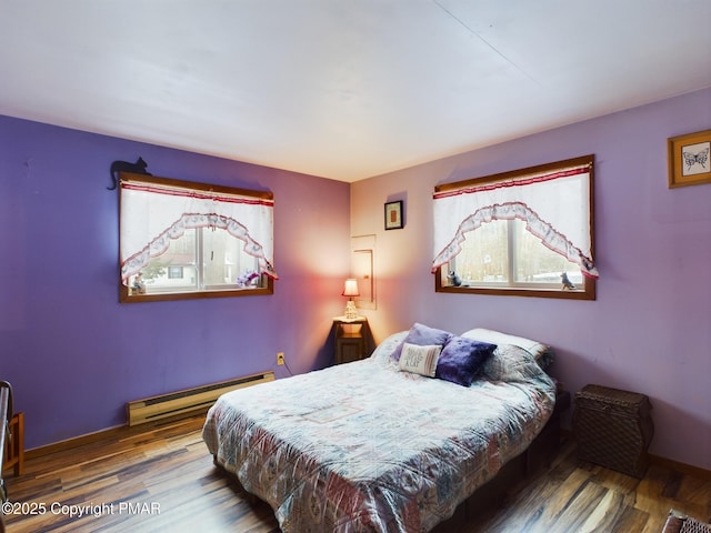 bedroom featuring a baseboard radiator, wood finished floors, and baseboards