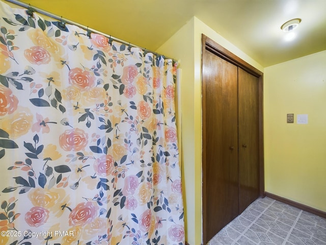 full bathroom featuring curtained shower and baseboards