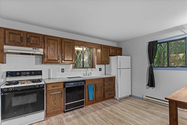 130 Deer Trail Dr, Saylorsburg, PA 18353 - kitchen with stove, black dishwasher, under cabinet range hood, a baseboard heating unit, and freestanding refrigerator