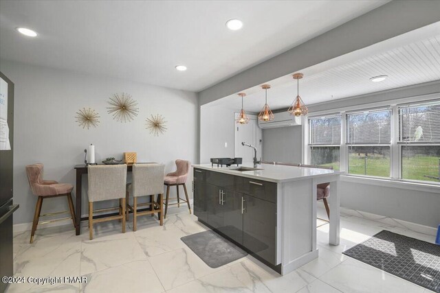 kitchen with recessed lighting, a sink, baseboards, marble finish floor, and hanging light fixtures