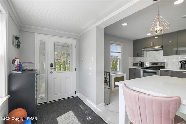 kitchen featuring under cabinet range hood, ornamental molding, stainless steel appliances, and backsplash